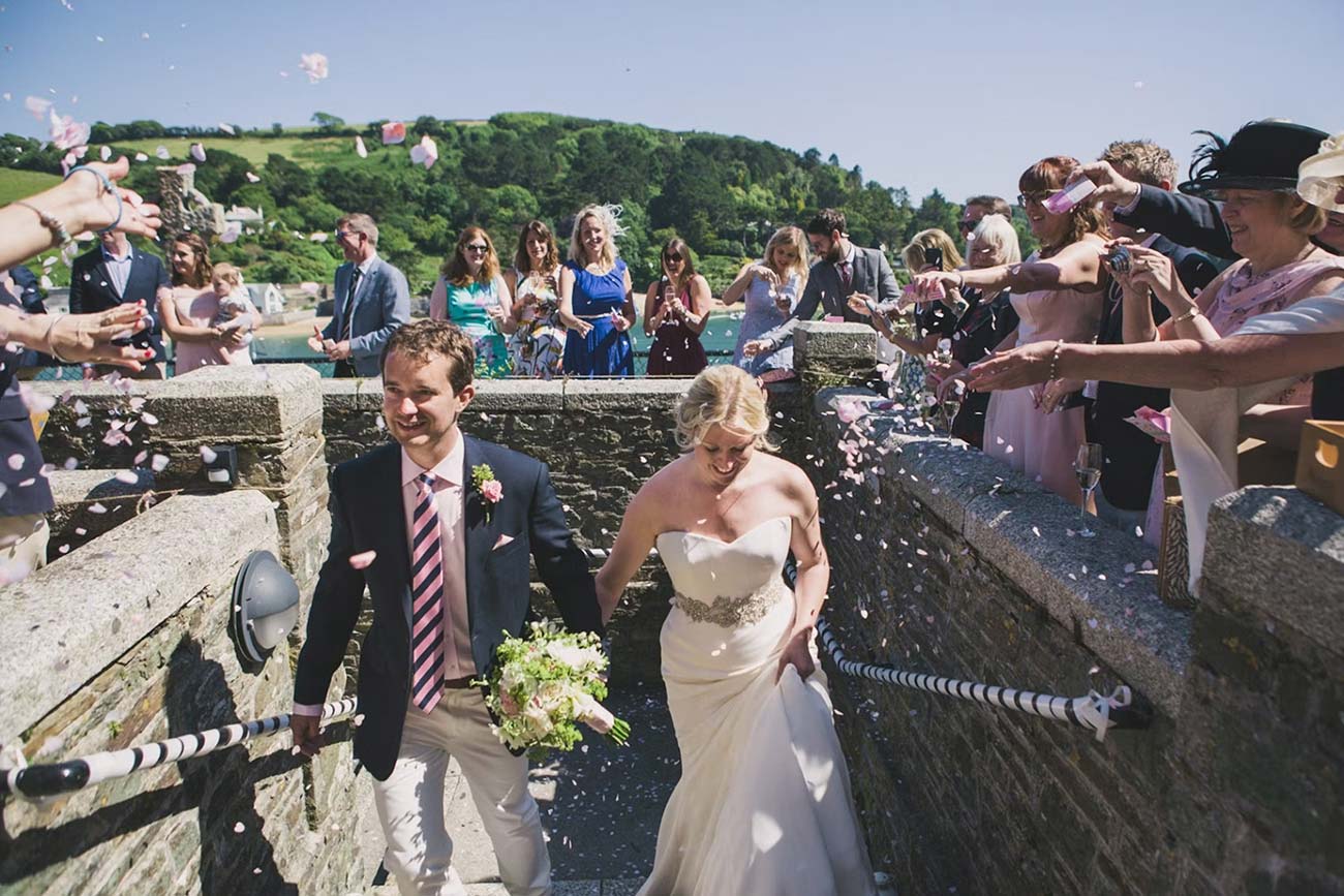 Wedding couple walking through confetti on the Cliff House terrace