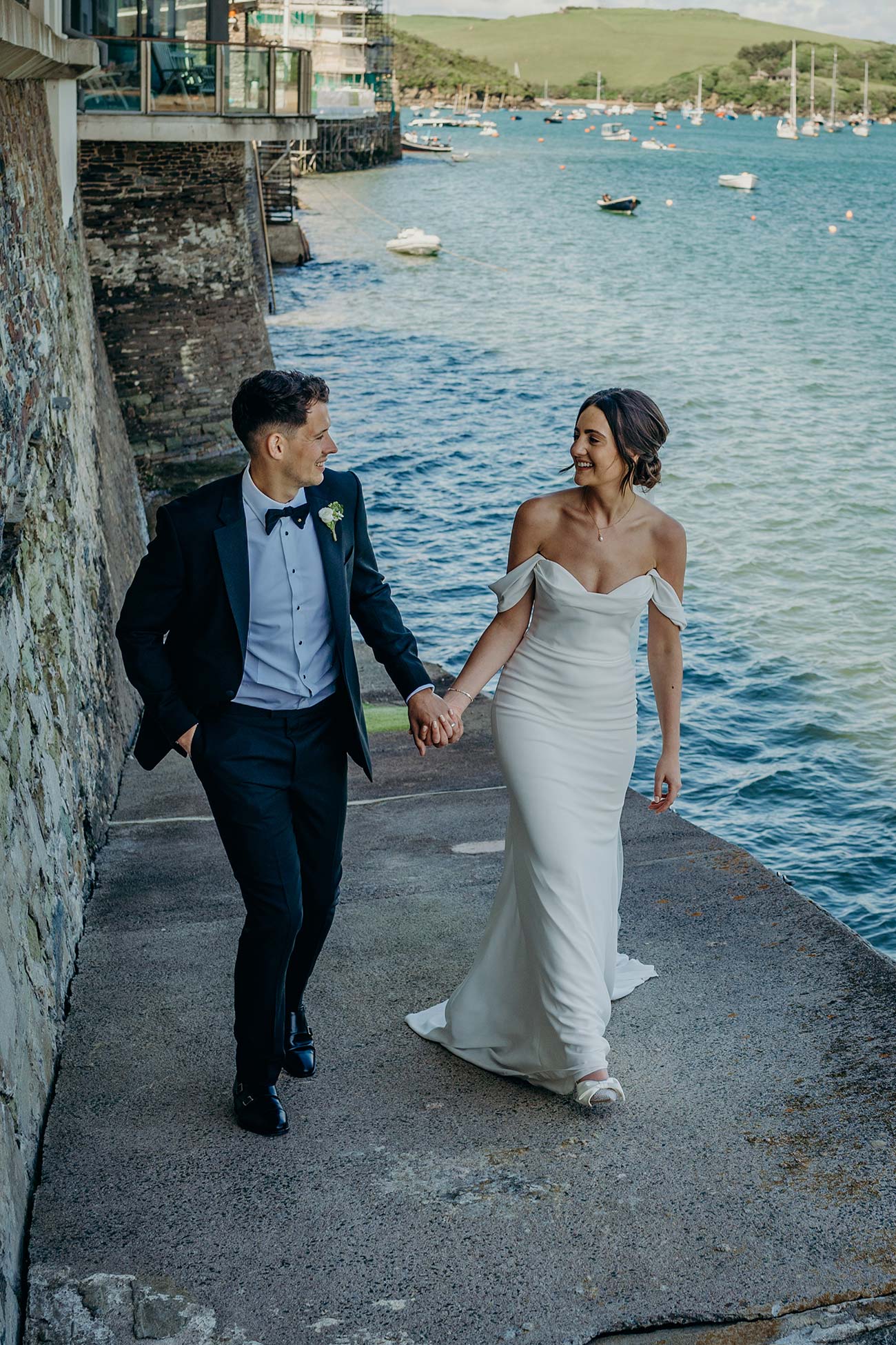 Wedding couple walking beside the Salcombe water